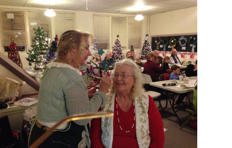 Woman getting her face painted at the festival of trees